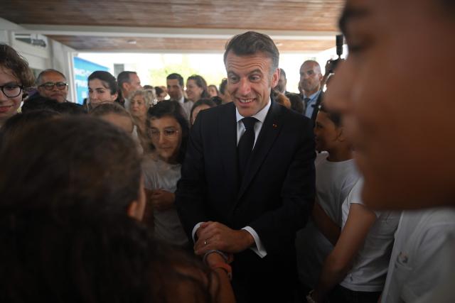 France's President Emmanuel Macron speaks with children during his visit to the French School in Nicosia on April 23, 2026, ahead of a meeting on the sidelines of a European summit. (Photo by Jewel SAMAD / AFP)