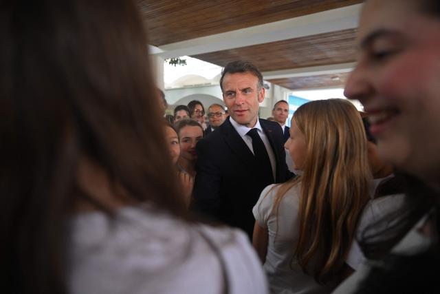 France's President Emmanuel Macron speaks with children during his visit to the French School in Nicosia on April 23, 2026, ahead of a meeting on the sidelines of a European summit. (Photo by Jewel SAMAD / AFP)