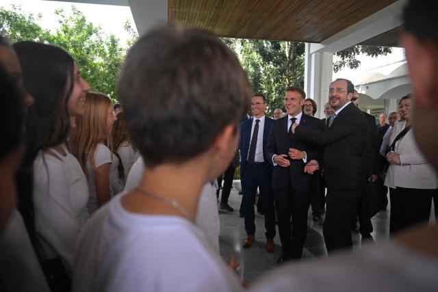 France's President Emmanuel Macron (C) and his Cypriot counterpart Nikos Christodoulides (center R) visit the French School in Nicosia on April 23, 2026, ahead of a meeting on the sidelines of a European summit. (Photo by Jewel SAMAD / AFP)