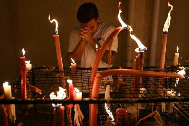 A man prays during Saint George's Day (Sao Jorge) celebrations at the Quintino neighborhood in Rio de Janeiro, Brazil on April 23, 2026. (Photo by Pablo PORCIUNCULA / AFP)