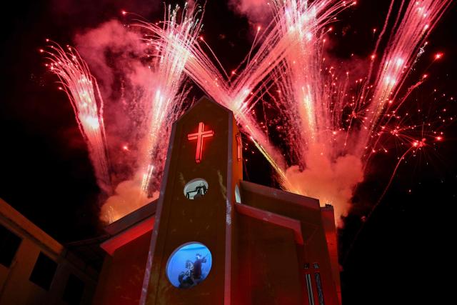 Fireworks explode at Saint George church during the Saint George's Day celebrations at the Quintino neighborhood in Rio de Janeiro, Brazil on April 23, 2026. (Photo by Pablo PORCIUNCULA / AFP)