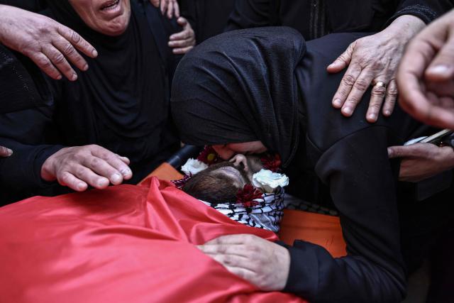 EDITORS NOTE: Graphic content / Relatives mourn the death of Awda Atef Awawdeh during his funeral in Deir Dibwan in the Israeli-occupied West Bank, on April 23, 2026. The Palestinian health ministry said Israeli settlers shot dead a Palestinian man in the occupied West Bank on April 22, the third victim of deadly gunfire in two days. The ministry said 25-year-old Awawdeh was killed by settler gunfire in the central West Bank town of Deir Dibwan, just east of Ramallah. (Photo by Zain JAAFAR / AFP)