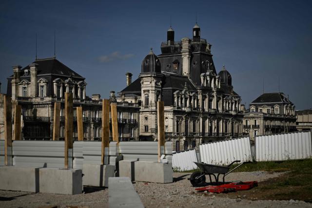 A preserved 19th-century stone building facade stands above groundwork at the Canopia urban redevelopment site near the Saint-Jean railway station in Bordeaux, south-western France, on April 23, 2026. The city's redevelopment push comes as the European Central Bank warned that the Iran conflict risks pushing energy-dependent European economies into stagflation, with French construction firms reporting fuel and materials cost hikes across active sites. (Photo by Philippe LOPEZ / AFP)