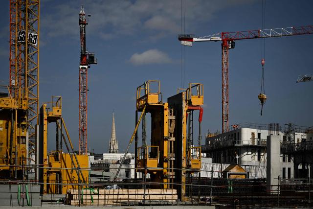 This photograph shows construction cranes and workers at the Canopia urban redevelopment site near the Saint-Jean railway station in Bordeaux, south-western France, on April 23, 2026. The city's redevelopment push comes as the European Central Bank warned that the Iran conflict risks pushing energy-dependent European economies into stagflation, with French construction firms reporting fuel and materials cost hikes across active sites. (Photo by Philippe LOPEZ / AFP)
