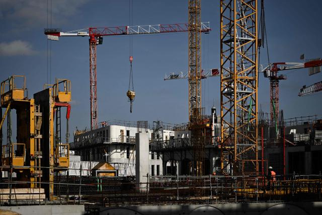 This photograph shows construction cranes and workers at the Canopia urban redevelopment site near the Saint-Jean railway station in Bordeaux, south-western France, on April 23, 2026. The city's redevelopment push comes as the European Central Bank warned that the Iran conflict risks pushing energy-dependent European economies into stagflation, with French construction firms reporting fuel and materials cost hikes across active sites. (Photo by Philippe LOPEZ / AFP)