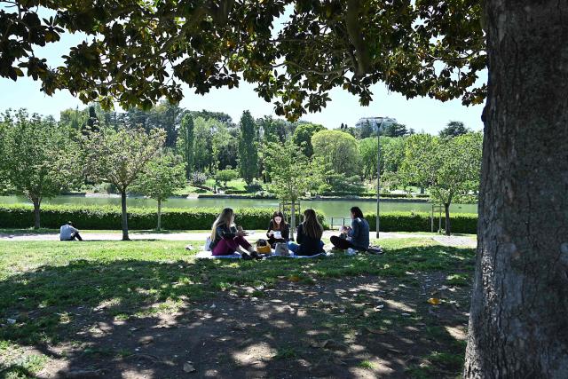 People are having a picnic in a park by the EUR lake (Parco Laghetto dell'EUR), in the EUR district of Rome, on April 23, 2026. (Photo by Andreas SOLARO / AFP)