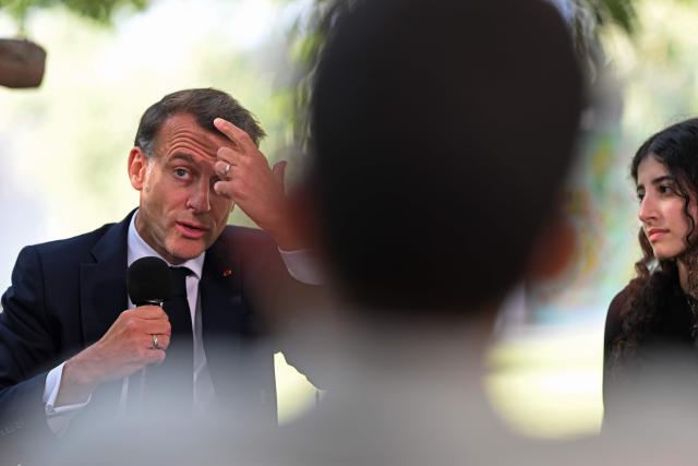 France's President Emmanuel Macron (L) addresses the students of the French School in Nicosia on April 23, 2026, ahead of a meeting on the sidelines of a European summit. (Photo by Jewel SAMAD / AFP)