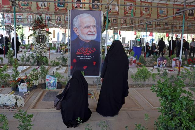People pray over the grave of the former Iranian foreign minister Kamal Kharazi at the Behesht Zahra Cemetery in the south of Tehran on April 23, 2026. Kharazi who had been serving as the head of the Strategic Council for International Relations, which is part of the foreign ministry, died from wounds suffered in US-Israel strikes on April 1, Iranian media reported. (Photo by AFP) / 