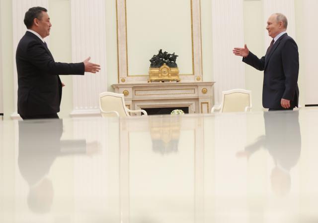Russian President Vladimir Putin and Kyrgyzstan's President Sadyr Japarov shake hands during their meeting at the Kremlin in Moscow on April 23, 2026. (Photo by MAXIM SHIPENKOV / POOL / AFP)