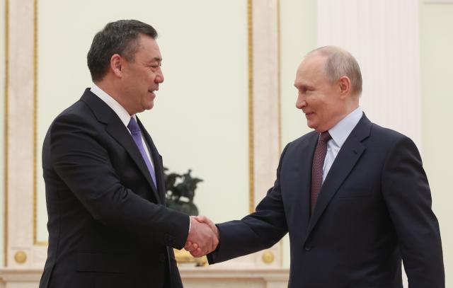 Russian President Vladimir Putin and Kyrgyzstan's President Sadyr Japarov shake hands during their meeting at the Kremlin in Moscow on April 23, 2026. (Photo by MAXIM SHIPENKOV / POOL / AFP)