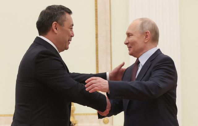 Russian President Vladimir Putin welcomes Kyrgyzstan's President Sadyr Japarov during their meeting at the Kremlin in Moscow on April 23, 2026. (Photo by MAXIM SHIPENKOV / POOL / AFP)