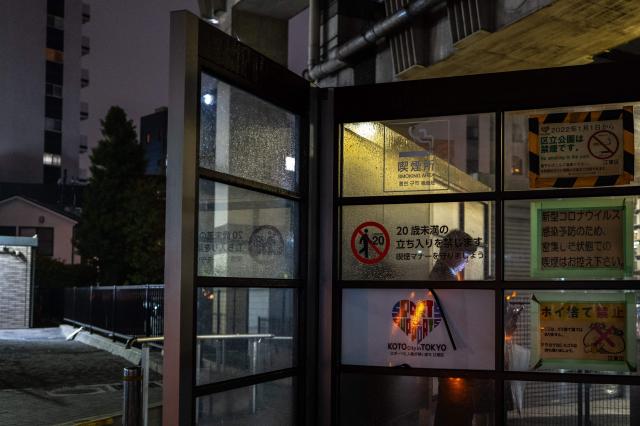 A man smokes in a designated smoking area in Tokyo on April 23, 2026. (Photo by Philip FONG / AFP)