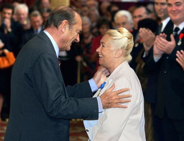 (FILES) French President Jacques Chirac (L) congratulates former ballerina Claude Bessy after awarding her the title of Grand Officer of the National Order of Merit on September 17, 2004 at the Elysee Palace in Paris, during a ceremony to present honours to a group of recipients. Former prima ballerina Claude Bessy, who headed the Paris Opera Ballet School for 30 years and revolutionised its teaching methods, died on April 23, 2026 at the age of 93, the institution announced. (Photo by PATRICK KOVARIK / AFP)