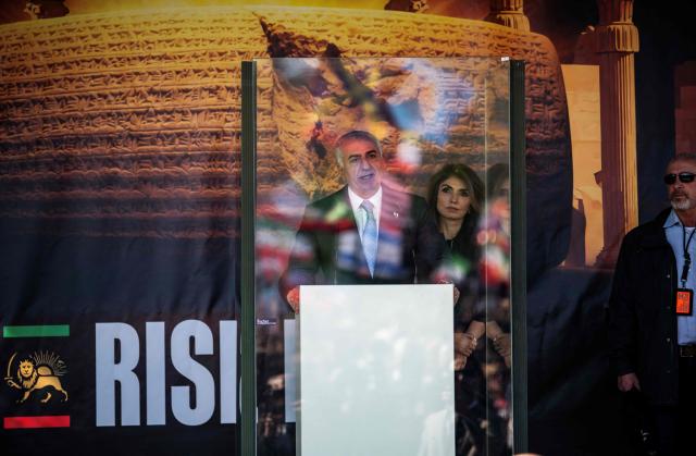 The son of Iran's last shah, exiled Crown Prince Reza Pahlavi (L) and his wife Yasmine Pahlavi stand on stage during a demonstration in Berlin, on April 23, 2026. Pahlavi said during a press conference that any negotiation with the religious authorities in Tehran amounted to a "policy of appeasement," expressing hope that new protests would eventually overthrow the regime. (Photo by John MACDOUGALL / AFP)