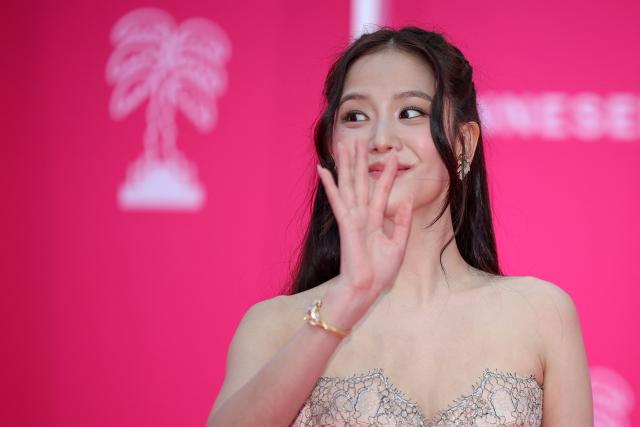 South-Korean singer Jisoo wavs as she poses on the pink carpet during the opening of the 9th edition of the Cannes International Series Festival (Canneseries) in Cannes, southern France, on April 23, 2026.  (Photo by Valery HACHE / AFP)