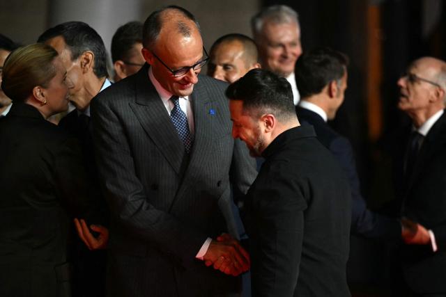 Germany's Chancellor Friedrich Merz (C) shakes hands with Ukraine's President Volodymyr Zelensky ahead of an informal meeting of the European Council, in Ayia Napa on April 23, 2026. (Photo by NICOLAS TUCAT / AFP)