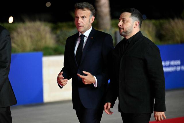 France's President Emmanuel Macron (L) and his Ukraine's counterpart Volodymyr Zelensky walk for a group photograph ahead of an informal meeting of the European Council, in Ayia Napa on April 23, 2026. (Photo by NICOLAS TUCAT / AFP)