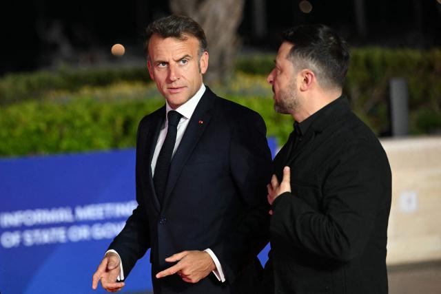 France's President Emmanuel Macron (L) and his Ukraine's counterpart Volodymyr Zelensky walk for a group photograph ahead of an informal meeting of the European Council, in Ayia Napa on April 23, 2026. (Photo by NICOLAS TUCAT / AFP)