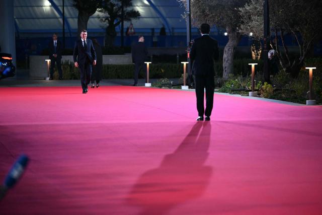 Cyprus' President Nikos Christodoulides (R) welcomes his French counterpart Emmanuel Macron upon the latter's arrival ahead of an informal meeting of the European Council, in Ayia Napa on April 23, 2026. (Photo by NICOLAS TUCAT / AFP)