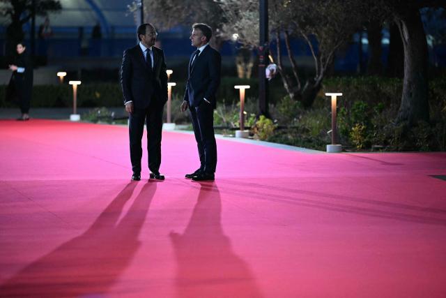 France's President Emmanuel Macron (R) speaks with his Cypriot counterpart Nikos Christodoulides upon his arrival ahead of an informal meeting of the European Council, in Ayia Napa on April 23, 2026. (Photo by NICOLAS TUCAT / AFP)