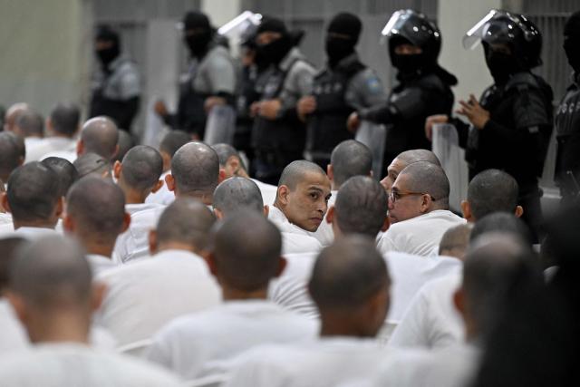 An alleged member of the Mara Salvatrucha (MS-13) gang gestures during a remote court hearing by videoconference at the Terrorism Confinement Center (CECOT) in Tecoluca, El Salvador on April 23, 2026. Nearly 490 alleged members of the powerful Central American gang Mara Salvatrucha (MS-13), including several alleged leaders, went on trial collectively in El Salvador, accused of thousands of murders. (Photo by MARVIN RECINOS / AFP)