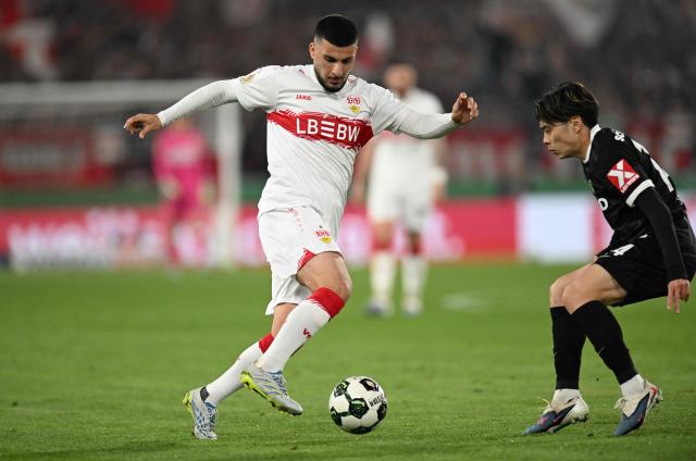 Stuttgart's German forward #26 Deniz Undav (L) and Freiburg's Japanese midfielder #14 Yuito Suzuki vie for the ball during the German Cup (DFB-Pokal) semi-final football match between VfB Stuttgart and FC Freiburg in Stuttgart, southwestern Germany, on April 23, 2026. (Photo by THOMAS KIENZLE / AFP) / DFB REGULATIONS PROHIBIT ANY USE OF PHOTOGRAPHS AS IMAGE SEQUENCES AND QUASI-VIDEO.