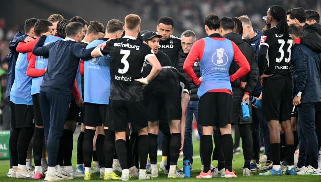 Freiburg's German head coach Julian Schuster (C-L) talks to his players prior to the extra time during the German Cup (DFB-Pokal) semi-final football match between VfB Stuttgart and FC Freiburg in Stuttgart, southwestern Germany, on April 23, 2026. (Photo by THOMAS KIENZLE / AFP) / DFB REGULATIONS PROHIBIT ANY USE OF PHOTOGRAPHS AS IMAGE SEQUENCES AND QUASI-VIDEO.