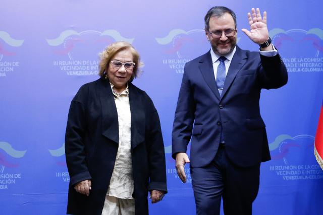 Venezuela's Foreign Minister Yvan Gil (R) waves beside his Colombian counterpart, Foreign Minister Rosa Yolanda Villavicencio, during a meeting in Caracas on April 23, 2026. (Photo by AFP stringer / AFP)