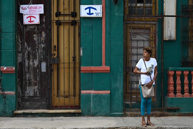 A man walks past a building for sale in Havana on April 23, 2026. Price hikes in some neighborhoods, intermediaries activity in social media, and growing interest from Cuban-American emigres: Havana's real estate market shows signs of revival in anticipation of possible economic or political changes on the communist island. (Photo by YAMIL LAGE / AFP)