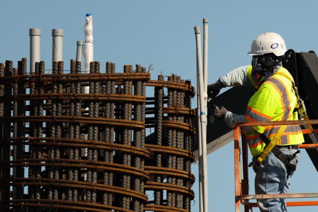 A construction worker builds a structure near Sepulveda Bopulevard as part of the ATMP Roadway Improvements Project to reduce airport traffic congestion at Los Angeles International Airport (LAX) in Los Angeles, California on April 23, 2026. The ingress roadways portion of the infrastructure project is scheduled to be completed before the 2028 Summer Olympic Games with final project completion in mid-2030. (Photo by Patrick T. Fallon / AFP)