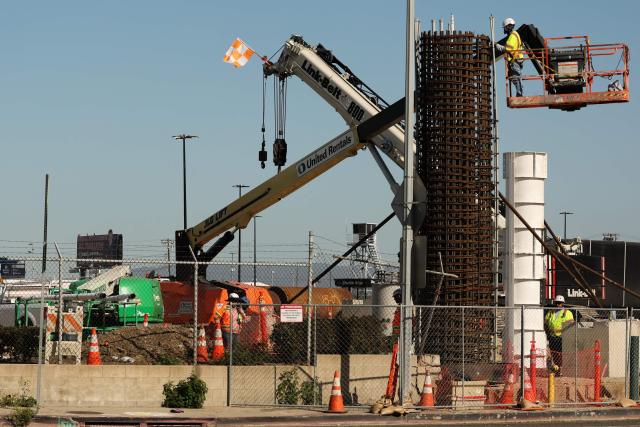 A construction worker builds a structure near Sepulveda Bopulevard as part of the ATMP Roadway Improvements Project to reduce airport traffic congestion at Los Angeles International Airport (LAX) in Los Angeles, California on April 23, 2026. The ingress roadways portion of the infrastructure project is scheduled to be completed before the 2028 Summer Olympic Games with final project completion in mid-2030. (Photo by Patrick T. Fallon / AFP)