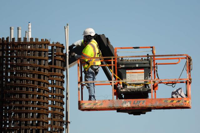 A construction worker builds a structure near Sepulveda Bopulevard as part of the ATMP Roadway Improvements Project to reduce airport traffic congestion at Los Angeles International Airport (LAX) in Los Angeles, California on April 23, 2026. The ingress roadways portion of the infrastructure project is scheduled to be completed before the 2028 Summer Olympic Games with final project completion in mid-2030. (Photo by Patrick T. Fallon / AFP)