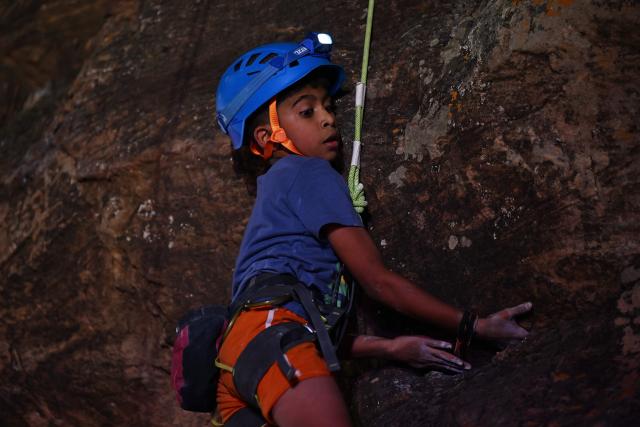 This photograph taken on March 28, 2026 shows a young climber scaling a rock wall during a rock climbing festival at a sandstone cliffs site in Karnataka's Badami town. India, a country obsessed with cricket, has seen a surge in popularity in climbing but those who want to compete internationally have had to crowd-fund and there is little government recognition or help.
The Indian Mountaineering Foundation (IMF) estimates there are tens of thousands of people who sport-climb regularly, with more than a dozen climbing gyms opening in the last decade.
But the rise in those picking it up as a professional career is slow -- high costs and scarce sponsorship deals hold back many. (Photo by Sajjad HUSSAIN / AFP) / TO GO WITH India-climbing, FOCUS by Pitcha Dangprasith, with Aishwarya Kumar in Bengaluru