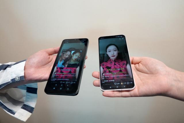 This photo illustration taken in Hong Kong on April 16, 2026 shows phones displaying screenshots of a video from Chinese model and influencer Christine Li accusing an AI microdrama of stealing her likeness without consent. Two people told AFP their likenesses were cast without consent in the AI-generated show "The Peach Blossom Hairpin", which ran on Hongguo, a major microdrama app owned by Tiktok parent company ByteDance.
Microdramas are ultra-short, online soap operas hugely popular in China and elsewhere.
Hongguo hosts thousands of free, bite-sized shows -- both live-action and AI-generated -- whose episodes are two or three minutes long. (Photo by Mahmoud RIZK / AFP) / To go with 'China-AI-Entertainment-Legal' focus by Sophia Xu and Purple Romero