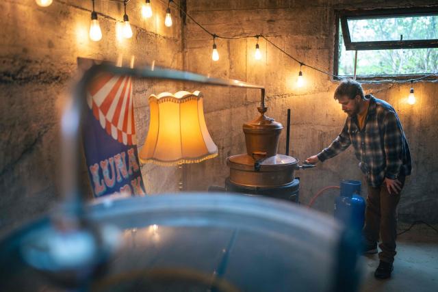 Ivan Lakatos works on the distillation process in his gin distillery in the village of Belegis near Stara Pazova, on March 28, 2026. In Serbia, as across much of the gin industry, juniper is not farmed but instead gathered from wild bushes by hand. Juniper has declined in parts of Europe over the past few decades particularly in lowland areas where it once grew. Studies show the species is struggling to regenerate in many areas, with climate change, grazing and habitat loss all contributing to declining populations. (Photo by Andrej ISAKOVIC / AFP)