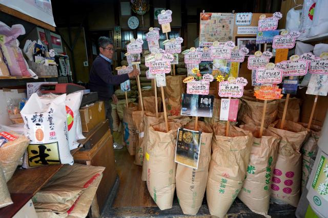 Bags of rice sourced from across the country are displayed for sale at a store in Tokyo on April 24, 2026. Japan's core inflation accelerated to 1.8 percent in March, government data showed April 24, largely driven by rising food prices. (Photo by Kazuhiro NOGI / AFP)