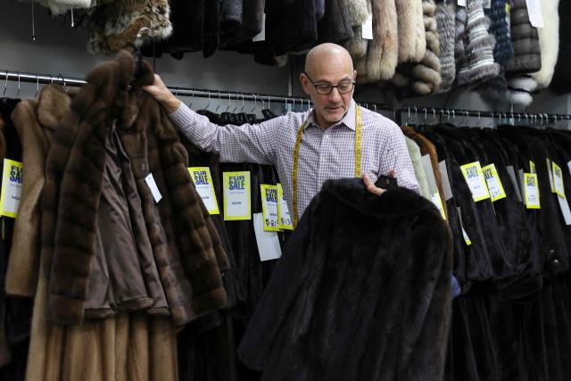 Larry Cowit, owner of Madison Avenue Furs shop, selects fur coats for a customer in his store in New York City, on March 10, 2026. New York is thawing out after a particularly cruel winter that's included debates over fur's revival as influencers push the look and retail sites report a jump in searches for vintage pieces. Business owners like Cowit, who inherited and runs his family's Madison Avenue Furs, are celebrating a sales spike. (Photo by ANGELA WEISS / AFP)