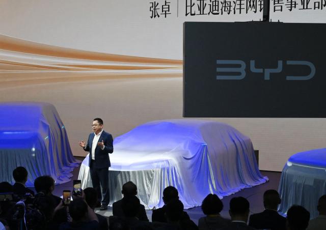 BYD CEO Wang Chuanfu speaks on stage as he unveils new car models on the opening day of the Beijing Auto Show in Beijing on April 24, 2026. (Photo by Danai Howard / AFP)