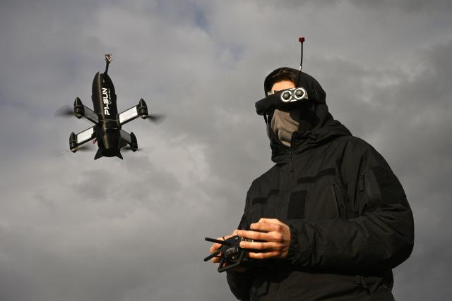 (FILES) An employee of the Ukrainian SkyFall company conducts a test flight with a P1-Sun interceptor drone at an undisclosed location in Ukraine on March 19, 2026, amid the Russian invasion of Ukraine. They mass-produce drones at virtually no cost and are constantly innovating: Ukrainian drone manufacturers are quietly traveling across France to share expertise forged in a war where these machines have already revolutionized combat and outpaced European armies. (Photo by Genya SAVILOV / AFP)