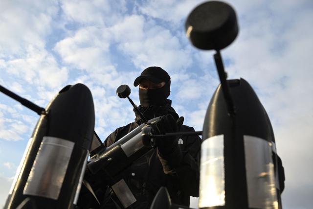 (FILES) An employee of the Ukrainian SkyFall company checks a P1-Sun interceptor drone before a test flight at an undisclosed location in Ukraine on March 19, 2026, amid the Russian invasion of Ukraine. They mass-produce drones at virtually no cost and are constantly innovating: Ukrainian drone manufacturers are quietly traveling across France to share expertise forged in a war where these machines have already revolutionized combat and outpaced European armies. (Photo by Genya SAVILOV / AFP)