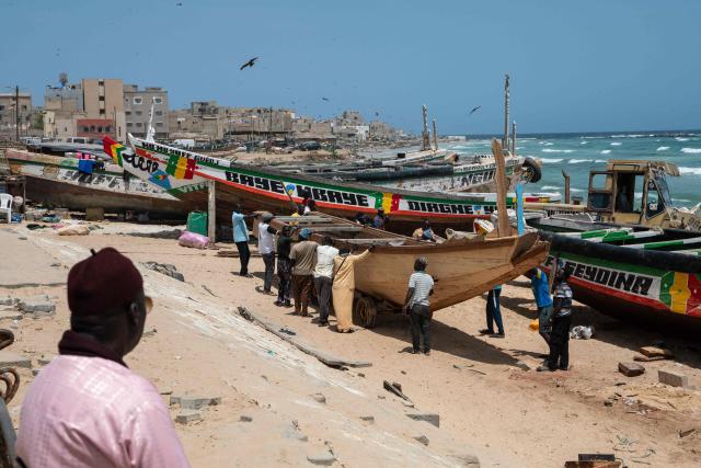 Fishermen pull a canoe ashore at Yoff Beach in Dakar, Senegal, on April 23, 2026. Small-scale fishing is a major activity in this part of Dakar along this stretch of coastline.According to a report published today, Yoff Beach is one of the sites identified as ‘at risk’ and requiring significant efforts to maintain water-based activities. A campaign to improve the quality of recreational waters in Senegal was launched today by the Surfrider Foundation Senegal and dozens of organisations along the Dakar coastline committed to protecting the ocean. They are leading a ‘Water Quality’ programme aimed at ensuring that coastal users can enjoy water-based activities without health risks, whilst contributing to the sustainable preservation of Senegal’s coastline. (Photo by NICOLAS REMENE / AFP)
