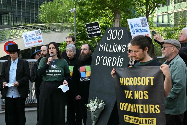 Demonstrators stage a protest to denounce the early retirement of 300 million computers, made obsolete by the forced upgrade from Windows 10 to Windows 11, called by several consumer associations in front of Microsoft France headquarters in Issy-les-Moulineaux, on the outskirts of Paris, on April 24, 2026. (Photo by Martin LELIEVRE / AFP)