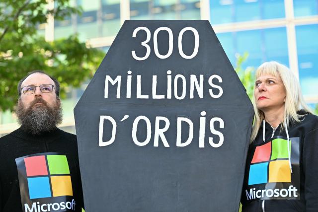 Demonstrators stage a protest to denounce the early retirement of 300 million computers, made obsolete by the forced upgrade from Windows 10 to Windows 11, called by several consumer associations in front of Microsoft France headquarters in Issy-les-Moulineaux, on the outskirts of Paris, on April 24, 2026. (Photo by Martin LELIEVRE / AFP)