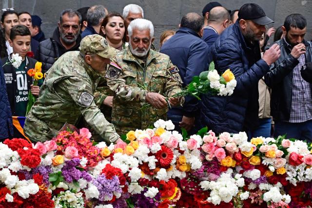 Armenians lay flowers at the Tsitsernakaberd Armenian Genocide Memorial on the Genocide Remembrance Day in Yerevan, on April 24, 2026, to mark the 111th anniversary of the World War I-era mass killings of Armenians under the Ottoman Empire in 1915. (Photo by KAREN MINASYAN / AFP)