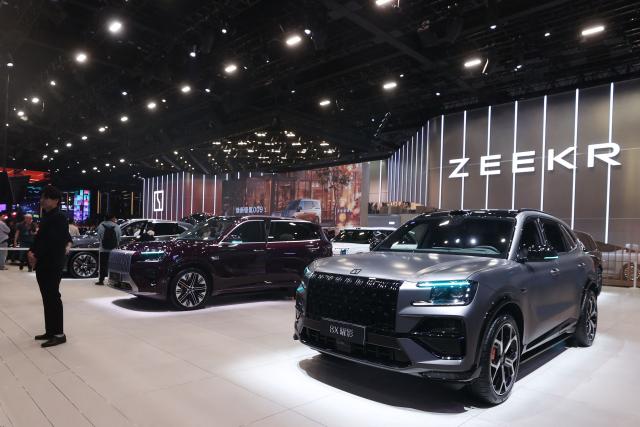 Visitors look at the Zeekr 8X (R) and other models on the opening day of the Beijing Auto Show in Beijing on April 24, 2026. (Photo by CN-STR / AFP) / China OUT