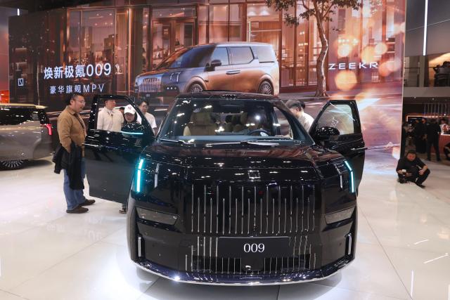 Visitors look at a Zeekr 009 on the opening day of the Beijing Auto Show in Beijing on April 24, 2026. (Photo by CN-STR / AFP) / China OUT