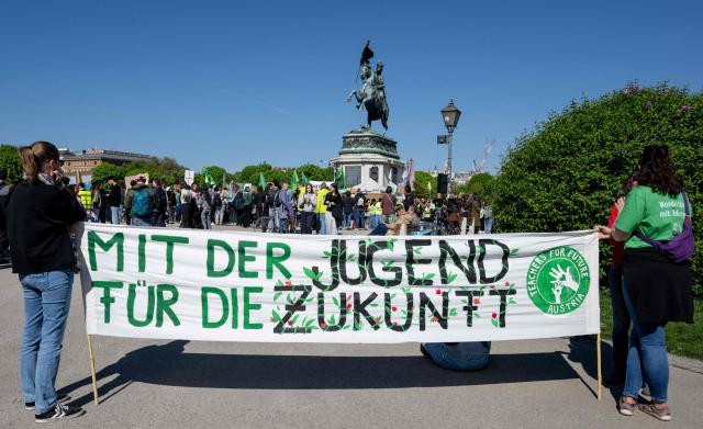 Demonstrators hold a banner reading " with the youths to the future" as students, teachers and environmental organizations attend a demonstration called by the Fridays For Future movement, "Our budget, our Future"  for an end of subsidies for oil and gas on April 24,2026, outside of the Hoffburg palace at the Helden square in Vienna, Austria. (Photo by Joe Klamar / AFP)