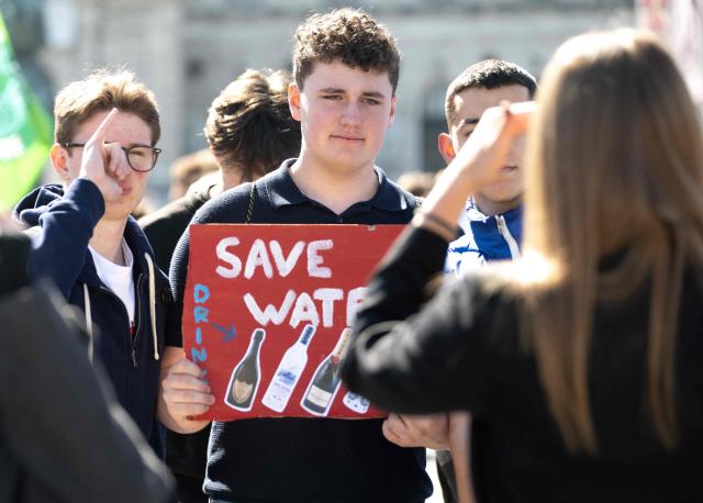 A demonstrator poses for a picture with his placard as he and students, teachers and environmental organizations attend a demonstration called by the Fridays For Future movement, "Our budget, our Future"  for an end of subsidies for oil and gas on April 24,2026, outside of the Hoffburg palace at the Helden square in Vienna, Austria. (Photo by Joe Klamar / AFP)