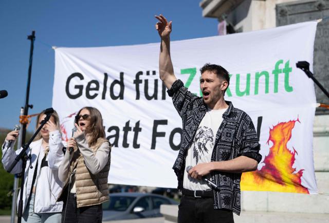 Activists perform on stage in front of students, teachers and environmental organizations during a demonstration called by the Fridays For Future movement, "Our budget, our Future"  for an end of subsidies for oil and gas on April 24,2026, outside of the Hoffburg palace at the Helden square in Vienna, Austria. (Photo by Joe Klamar / AFP)