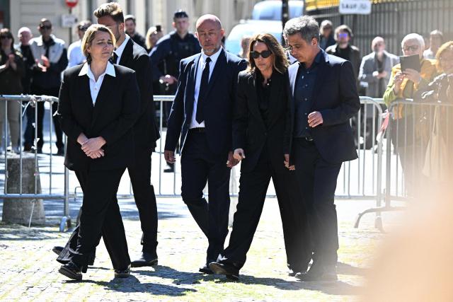 French actress Laura Smet talks with her husband and lawyer Raphael Lancrey-Javal after attending the funeral ceremony of her mother, French actress Nathalie Baye at the Saint-Sulpice church in Paris on April 24, 2026. French film star Nathalie Baye died on April 17, 2026, at the age of 77. (Photo by JULIEN DE ROSA / AFP)